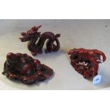Three Chinese resin red figures:- resting Buddha, tiger and dragon