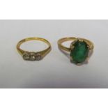 An 18ct three stone illusion ring and green stone ring