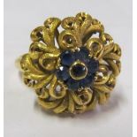 A yellow metal ring marked 750 blue cluster centre and pierced border