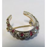 A 9ct gold red stone and diamond crescent brooch