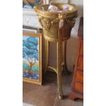 A decorative gilt cane and wood jardinière with garland and animal head carving