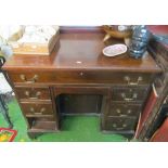 A small mahogany kneehole desk of seven drawers with central cupboard