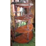 A Victorian mahogany four tier demi-lune shelf with wrythen twist supports