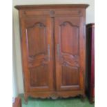 A 19th Century walnut armoire with two carved panelled doors