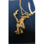 An articulated pendant witch on broom on fine gold coloured chain