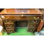 A small mahogany kneehole desk of seven drawers with central cupboard