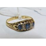 An 18ct gold three stone sapphire and diamond ring size O 2.5gm