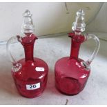 A pair of Cranberry glass decanters with clear stoppers
