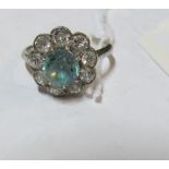 A platinum ring with nine diamonds and a light blue stone