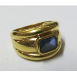 A gold coloured ring set blue stone 5.68gm