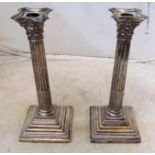 A pair of tall silver candlesticks