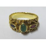 A gold coloured ring set red, green and blue stones, marked 750 6gm