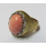 A coral ring with diamond surround
