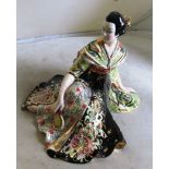 An Italian pottery Japanese figure of a seated geisha with flowing kimono