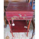 An oriental lacquer sewing table with lift up lid revealing fitted interior, above two drawers and