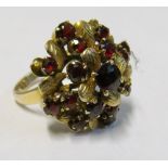 A yellow metal garnet princess style domed cluster ring