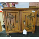 An Edwardian two door smoker's cabinet with decorative brass hinges, some smokers items and a card