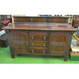 A large 1920s carved oak sideboard with three central drawers and two cupboards