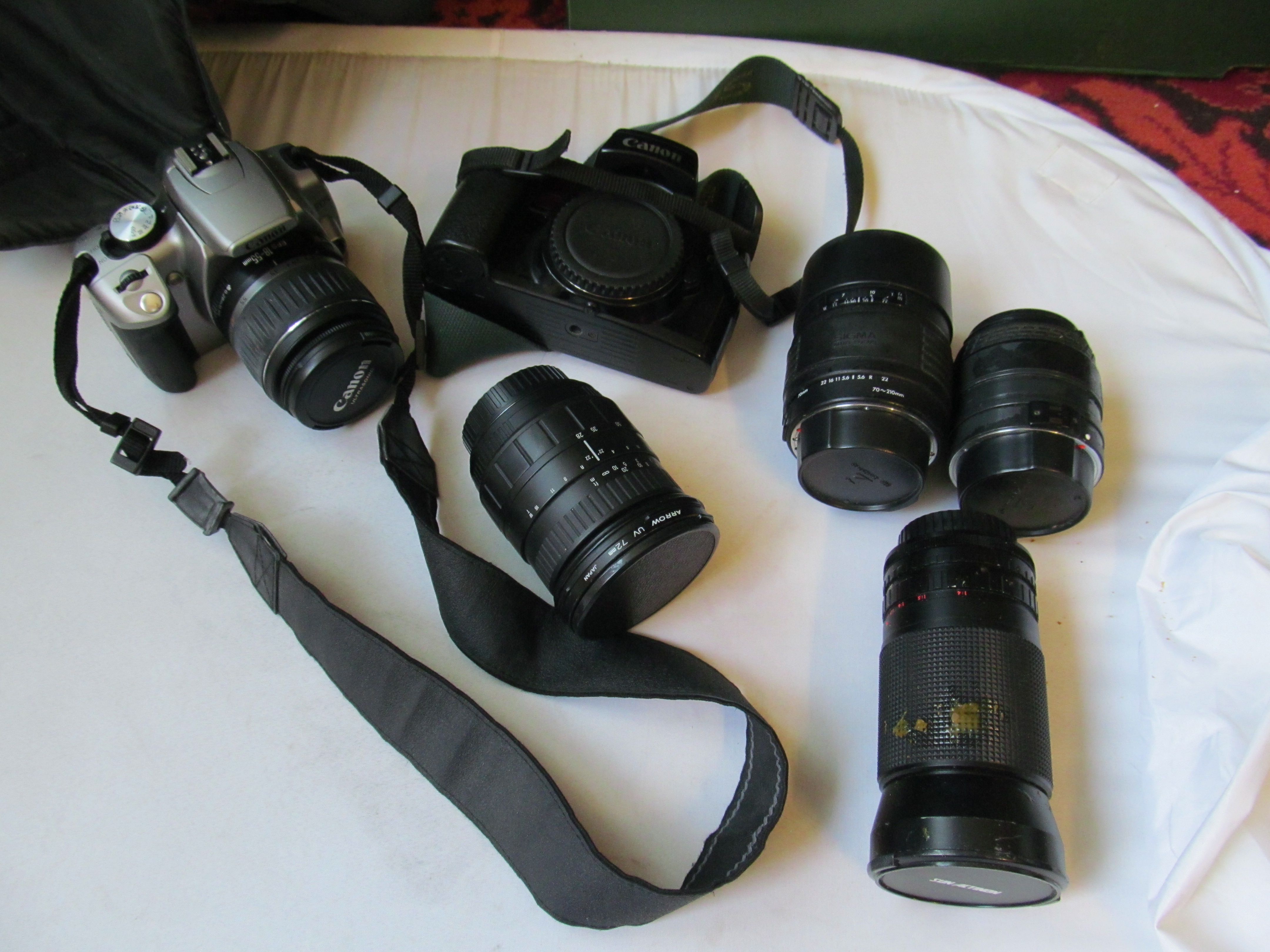 A Canon EOS with lens and older EOS camera, six lenses, filters, tripod et cetera