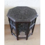 A carved Indian octagonal top table on pierced folding stand