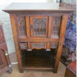 A carved oak cabinet two linenfold cupboards above