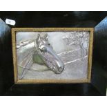 A metal relief picture of a horses head monogrammed HB