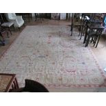 A Chinese beige ground wool carpet with design of red, yellow and beige flowers 9' x 12'