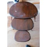 A nest of three dark wood Ercol pebble tables