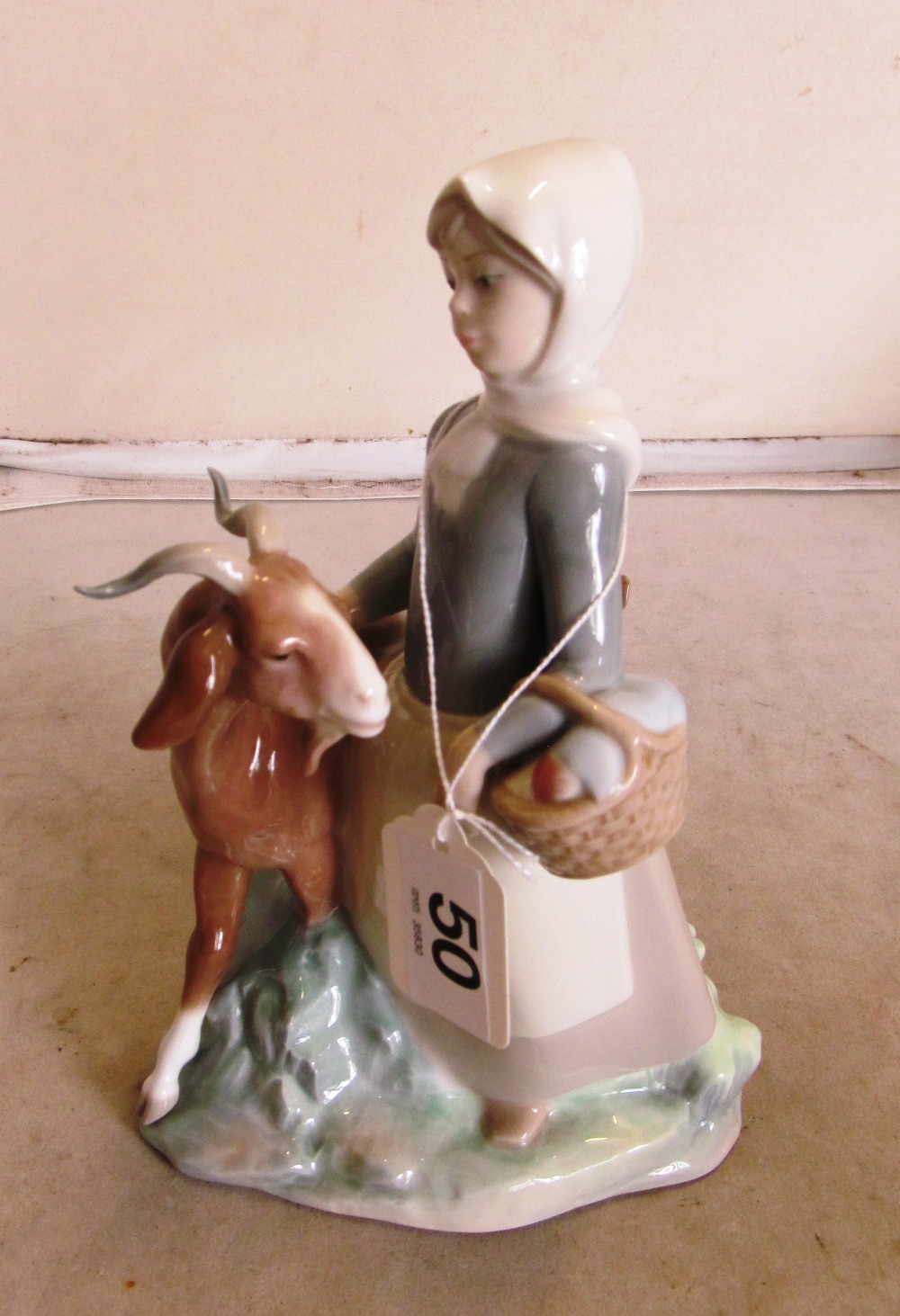 A Lladro figure girl carrying basket with goat