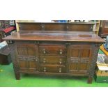 A large 1920s carved oak sideboard with three central drawers and two cupboards