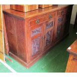 A large oak sideboard two drawers and four panelled cupboards with carved detail