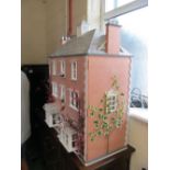 A brick style doll's house with bay windows and fitted furniture