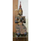 An Oriental carved wood kneeling figure