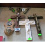 A wooden cross with brass figure of Christ, two others and plaque with bowl