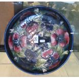 A Moorcroft dish pink and purple anemones on blue ground (restored)