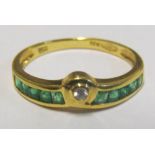 A gold coloured ring set diamond and emeralds marked 750 and 18k 2.1g, size N/O