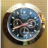 A Rolex style battery operated wall clock with black and rose gold coloured dial