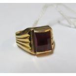 A gold coloured ring set red stone marked 35