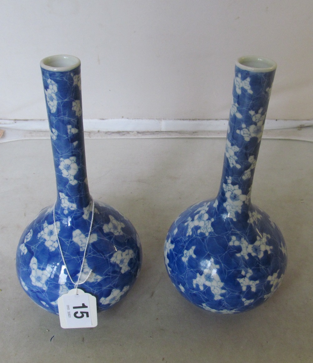 A pair of blue and white long necked vases floral design