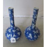 A pair of blue and white long necked vases floral design