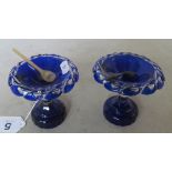 A pair of blue glass pedestal salts and spoons