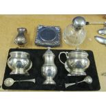 A silver shaped spoon, pepper, tongs, three piece condiment set et cetera