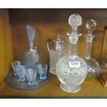 A claret decanter with plated mask head lid, two other decanters and an Art Deco style blue glass