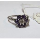 An 18ct white gold ring set diamond and purple stone cluster