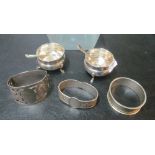 A pair of silver salts and spoons, two silver napkin rings and a continental napkin ring
