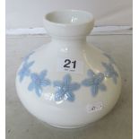 A Lladro vase blue flowers on a white ground