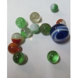 A large Victorian blue glass marble and eleven small marbles