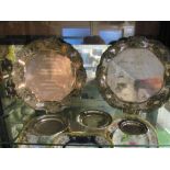 Two white metal salvers and three small white metal trays