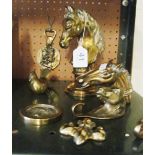 A brass horses head on circular base and other brass ornaments