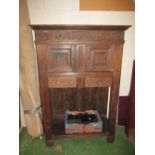 An 18th Century carved oak cupboard with two drawers and recess under